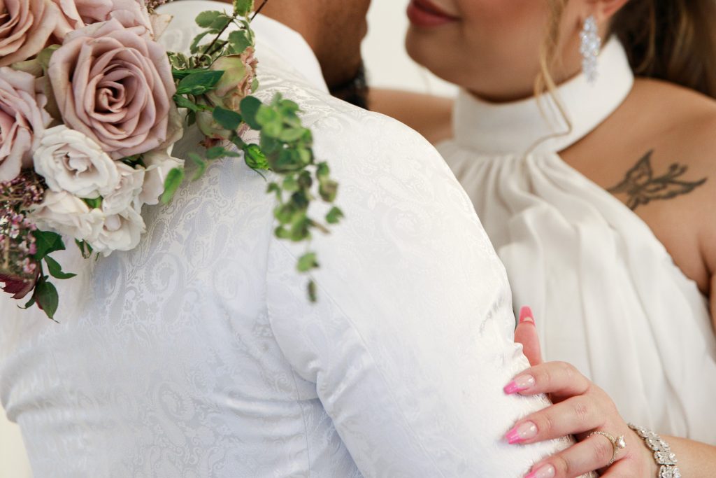 Texas bride and groom getting close with the bouquet and showing off the ring. Wedding photography. Wedding ring. Kisses.